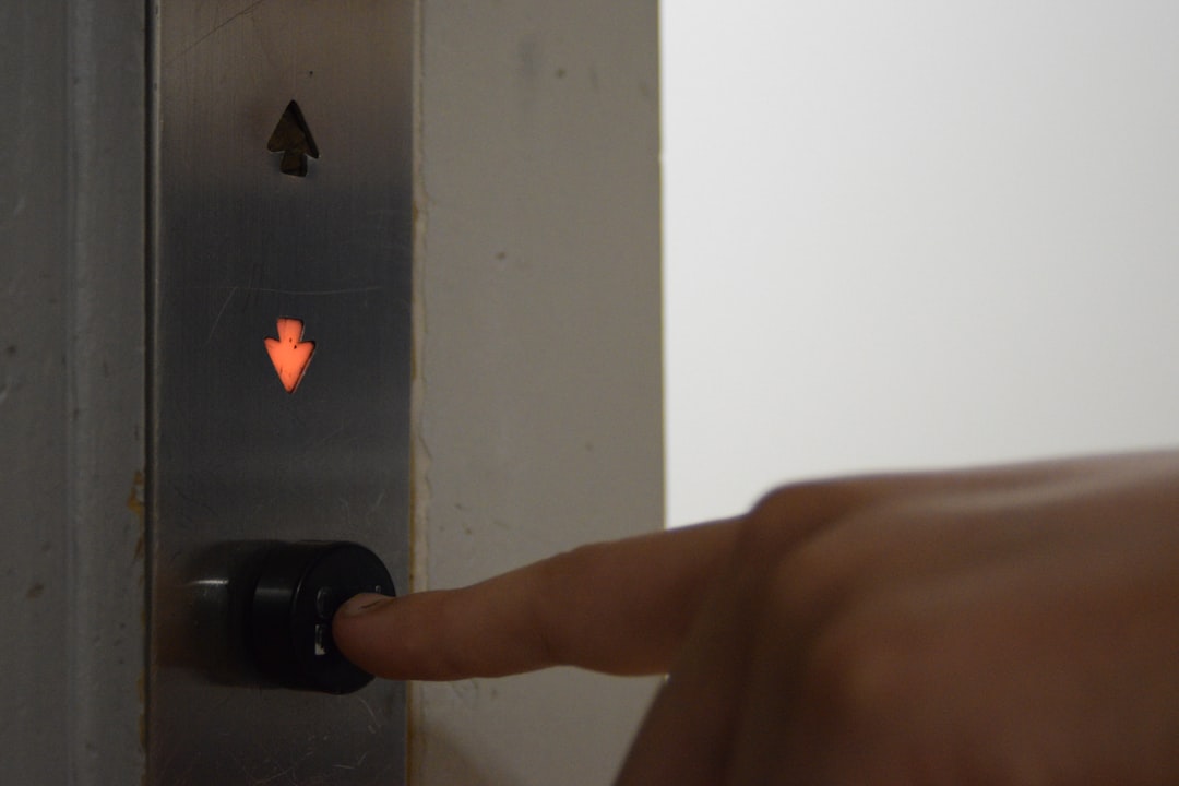 Detailed, close-up shot of a person's hands carefully using a screwdriver to install a sleek, modern smart lock onto a fro...