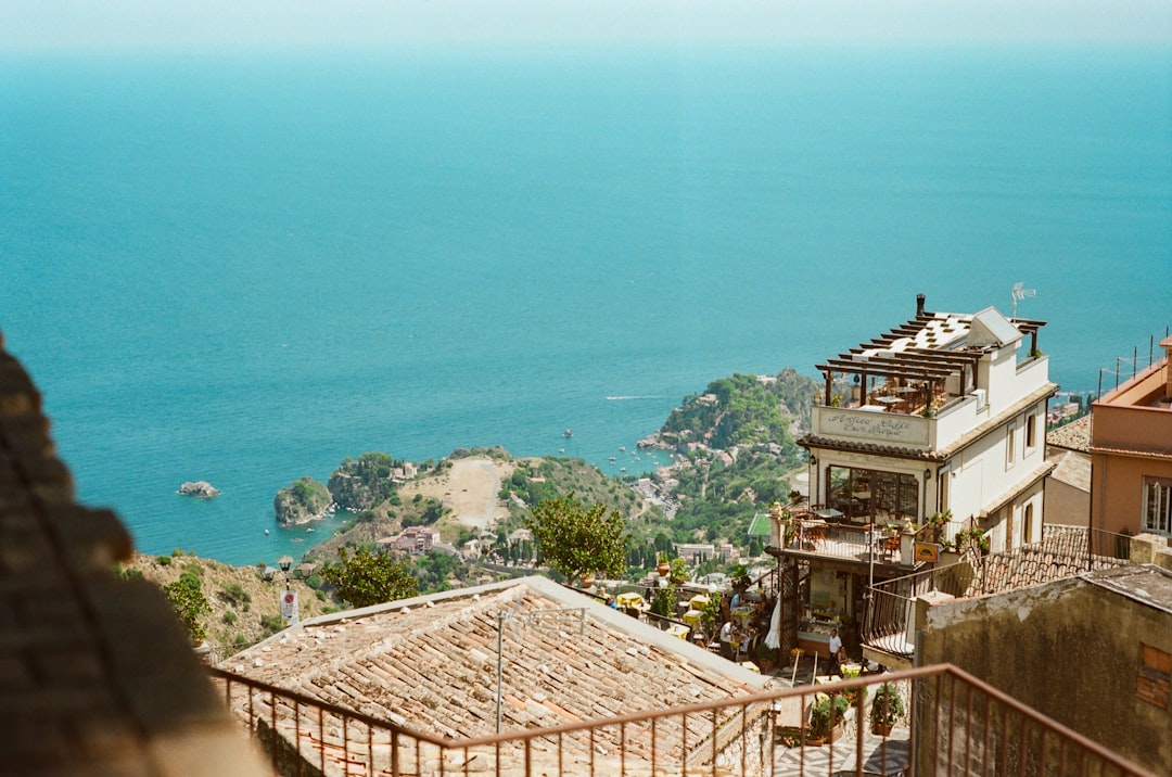 A relaxed couple sips coffee on a modern balcony, enjoying the morning light and a beautiful scenic view from their vacation home.